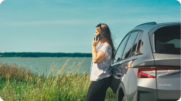 dame står med telefon ude foran en elroq